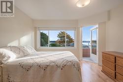 Bedroom with light hardwood / wood-style floors, access to exterior, and a water view - 