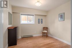 Unfurnished room featuring a baseboard heating unit and light hardwood / wood-style floors - 