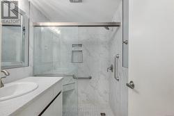 Bathroom with vanity and a shower with door - 