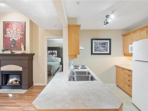 303-5660 Edgewater Lane, Nanaimo, BC - Indoor Photo Showing Kitchen With Fireplace With Double Sink