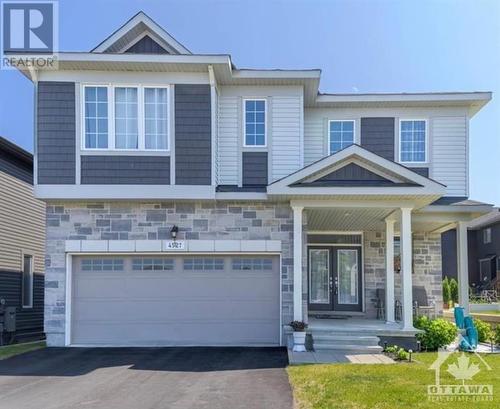 Picture perfect curb appeal with gorgeous stonework and a charming covered front porch. Plenty of parking for guests. - 4527 Kelly Farm Drive, Ottawa, ON - Outdoor With Facade