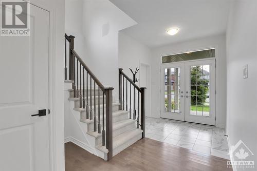 Double doors with glass lets the light in and leads to a spacious foyer. - 4527 Kelly Farm Drive, Ottawa, ON - Indoor Photo Showing Other Room