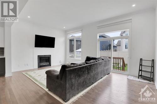 The oversized windows flood the entire space in natural light. - 4527 Kelly Farm Drive, Ottawa, ON - Indoor Photo Showing Living Room With Fireplace