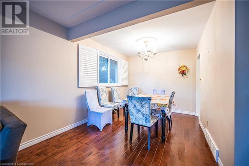 Dining area featuring an inviting chandelier and dark hardwood / wood-style floors - 580 Highpoint Avenue Unit# Upper, Waterloo, ON - Indoor Photo Showing Dining Room