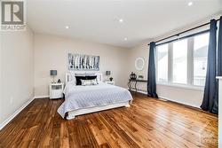 Primary bedroom with acacia wood floors - 