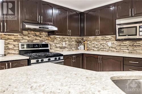 Quartz counters, gas stove and high efficiency hood fan. - 26 Portadown Crescent, Ottawa, ON - Indoor Photo Showing Kitchen With Upgraded Kitchen