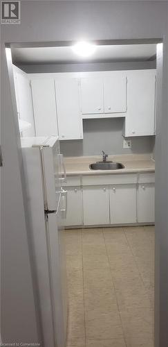 Kitchen featuring white cabinetry, sink, and white fridge - 76 Brybeck Crescent Unit# 105, Kitchener, ON - Indoor Photo Showing Kitchen