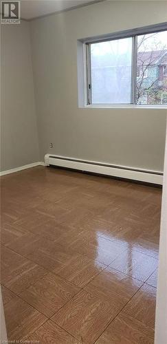 Empty room featuring a baseboard heating unit - 76 Brybeck Crescent Unit# 105, Kitchener, ON - Indoor Photo Showing Other Room