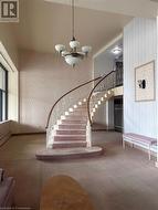 Stairway with baseboard heating, carpet flooring, and a notable chandelier - 