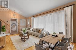 Photo is virtually staged. There's hardwood flooring underneath the carpet. The rendering is to give ideas on how it could be set up to allow for a dining area and living room area combination. - 