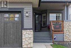 This home has amazing curb appeal with a terrific blend of exposed aggregate, stone and vinyl siding exteriors, and a premium garage door - 