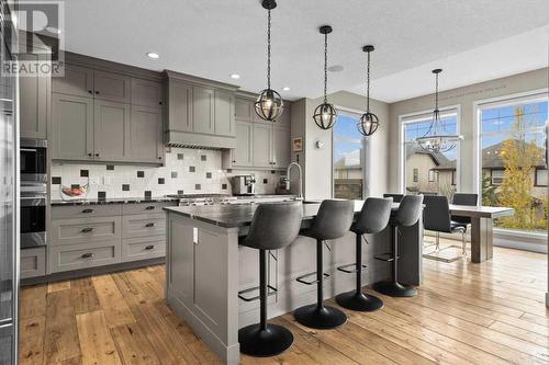 The kitchen and dining nook overlook the sunny and private landscaped backyard - 209 Hidden Creek Road Nw, Calgary, AB - Indoor Photo Showing Kitchen With Upgraded Kitchen