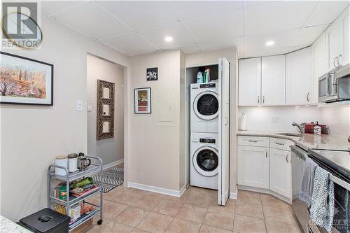 stackable laundry machines located in kitchen - 141 Somerset Street Unit#601, Ottawa, ON - Indoor Photo Showing Laundry Room