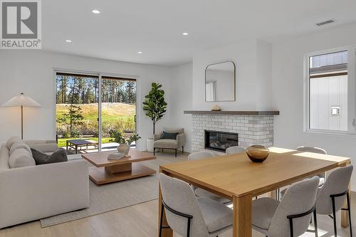 Dining and living room - Photo of a similar home in the community. - 1979 Country Club Drive Unit# 7, Kelowna, BC - Indoor With Fireplace