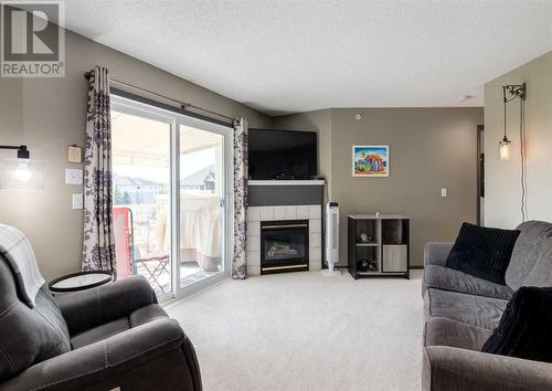 410, 6000 Somervale Court Sw, Calgary, AB - Indoor Photo Showing Living Room With Fireplace