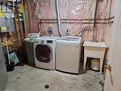 Laundry area featuring tankless water heater and washer and clothes dryer - 