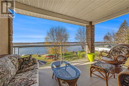 Primary bedroom with a private balcony to enjoy morning coffee and evening sunsets - 36 R1 Road, Rideau Lakes, ON - Indoor Photo Showing Bedroom With Fireplace