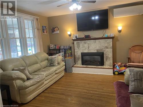 Living room featuring hardwood / wood-style flooring, ceiling fan, and a fireplace - 76 10Th Street, Hanover, ON - Indoor Photo Showing Living Room With Fireplace