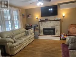 Living room featuring hardwood / wood-style flooring, ceiling fan, and a fireplace - 