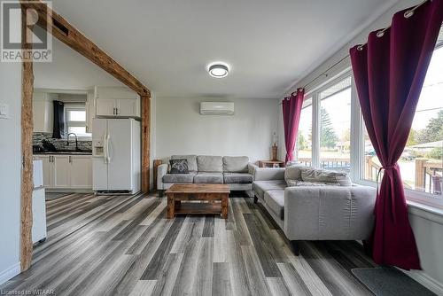 Living room with an AC wall unit, sink, beam ceiling, and dark hardwood / wood-style flooring - 824 Devonshire Avenue, Woodstock, ON - Indoor Photo Showing Living Room