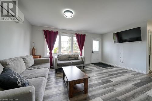 Living room with a wall mounted air conditioner and hardwood / wood-style floors - 824 Devonshire Avenue, Woodstock, ON - Indoor Photo Showing Living Room