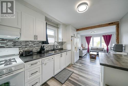 Kitchen featuring light hardwood / wood-style floors, white cabinetry, sink, and white appliances - 824 Devonshire Avenue, Woodstock, ON - Indoor Photo Showing Kitchen With Double Sink