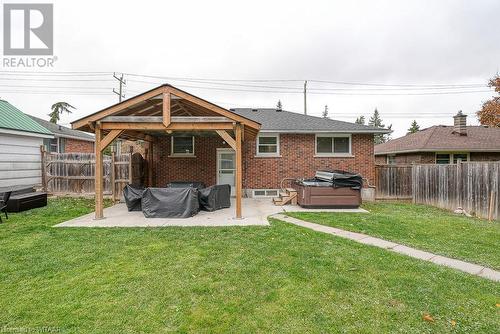 Back of house featuring a hot tub, a yard, and a patio - 824 Devonshire Avenue, Woodstock, ON - Outdoor With Exterior