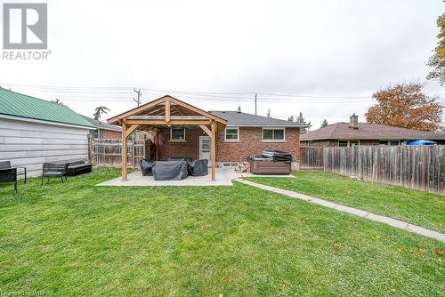 Rear view of property featuring a hot tub, a yard, and a patio - 824 Devonshire Avenue, Woodstock, ON - Outdoor