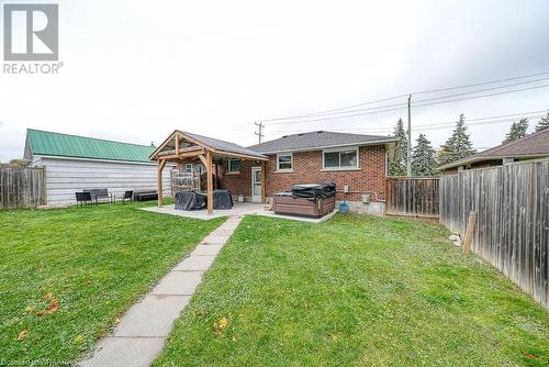 Rear view of property featuring a patio, a hot tub, and a yard - 824 Devonshire Avenue, Woodstock, ON - Outdoor With Deck Patio Veranda