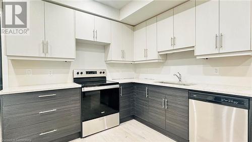 Kitchen with sink, light stone countertops, white cabinets, light wood-type flooring, and appliances with stainless steel finishes - 783 Autumn Willow Drive Unit# Lower, Waterloo, ON - Indoor Photo Showing Kitchen