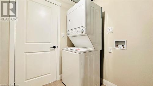 Clothes washing area featuring light hardwood / wood-style floors and stacked washer and dryer - 783 Autumn Willow Drive Unit# Lower, Waterloo, ON - Indoor Photo Showing Laundry Room