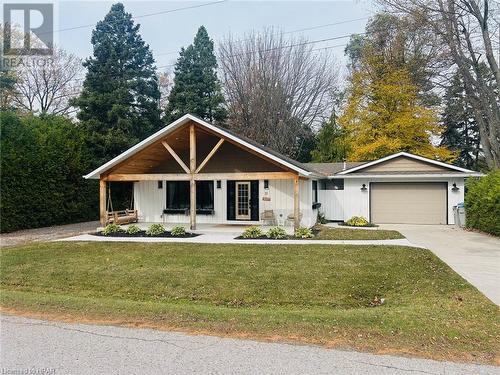 View of front facade with a garage, a front lawn, and covered porch - 31 Glass Street, Bayfield, ON - Outdoor