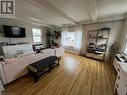 Living room with baseboard heating, beam ceiling, and light wood-type flooring - 310 Main Street, Mattawa, ON  - Indoor Photo Showing Living Room 