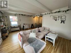 Living room with hardwood / wood-style flooring and beam ceiling - 