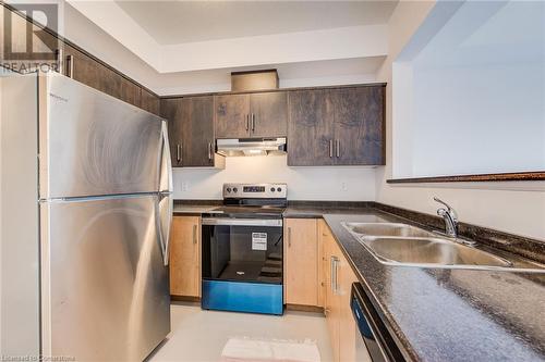 Kitchen featuring dark brown cabinets, sink, and appliances with stainless steel finishes - 26 Elsegood Drive, Guelph, ON - Indoor Photo Showing Kitchen With Double Sink