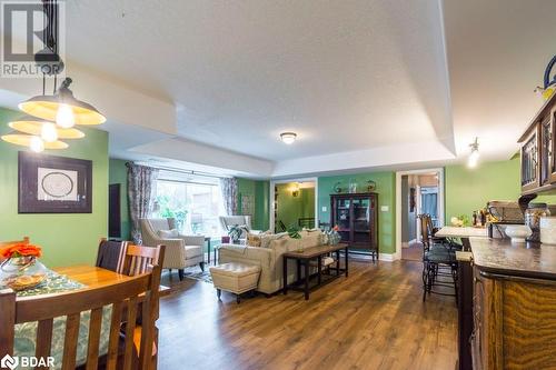 Living room with a textured ceiling, dark hardwood / wood-style floors, and a tray ceiling - 145 Farley Avenue Unit# 103, Belleville, ON - Indoor