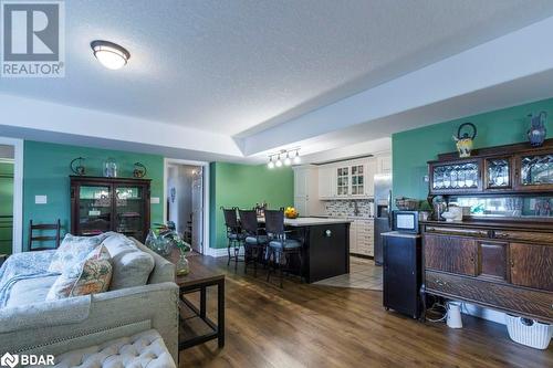 Living room featuring a textured ceiling, bar, and dark hardwood / wood-style floors - 145 Farley Avenue Unit# 103, Belleville, ON - Indoor Photo Showing Living Room