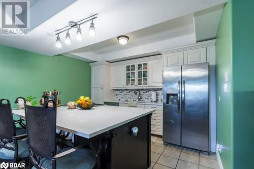 Kitchen with stainless steel fridge, white cabinetry, backsplash, light tile patterned floors, and sink - 145 Farley Avenue Unit# 103, Belleville, ON - Indoor Photo Showing Other Room