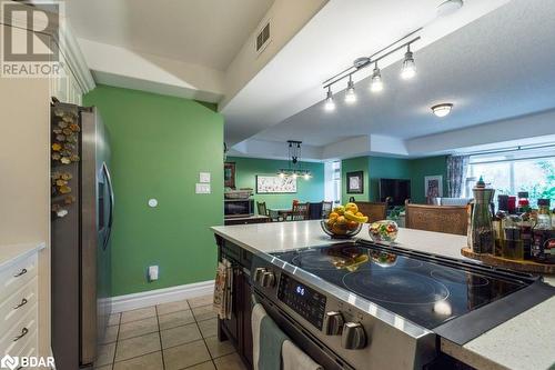 Kitchen featuring appliances with stainless steel finishes, hanging light fixtures, light tile patterned floors, and white cabinets - 145 Farley Avenue Unit# 103, Belleville, ON - Indoor Photo Showing Kitchen