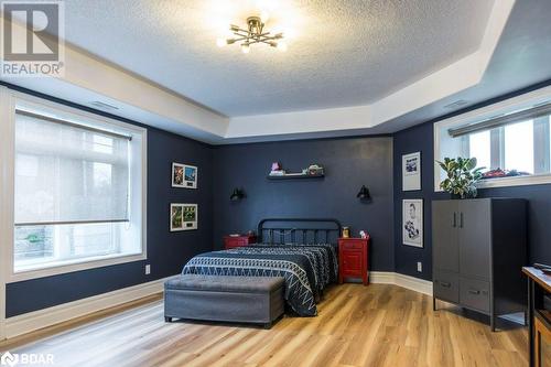 Bedroom with light hardwood / wood-style floors, multiple windows, and a raised ceiling - 145 Farley Avenue Unit# 103, Belleville, ON - Indoor Photo Showing Bedroom