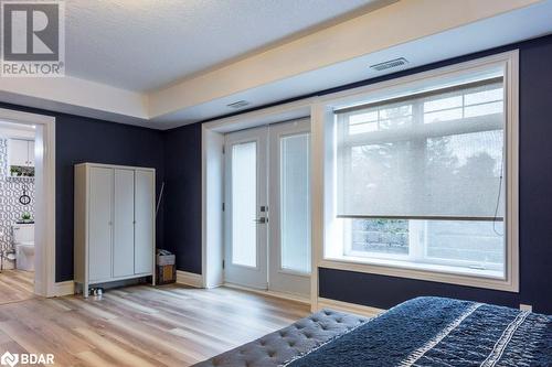 Bedroom with a textured ceiling, light hardwood / wood-style floors, and ensuite bathroom - 145 Farley Avenue Unit# 103, Belleville, ON - Indoor Photo Showing Bedroom