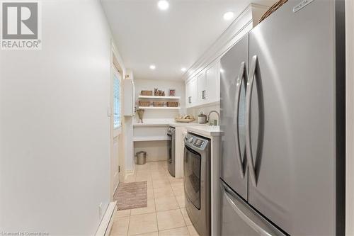 Laundry room remodelled 2023 by Gravelle. Frigidare stainless fridge, Maytag washer and dryer. Quartz countertop. Beautiful Shaker cabinetry. Deep stainless sink with Kohler handspray. Door to side ga - 3040 First Street, Burlington, ON - Indoor Photo Showing Laundry Room