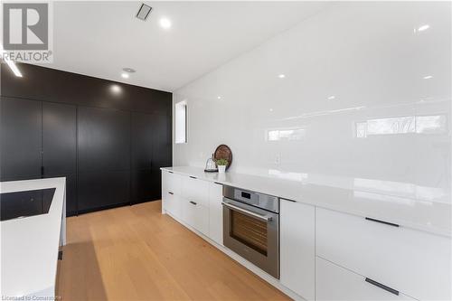 Integrated Thermador fridge. freezer, microwave, shelving (inside black cabinetry). White oak flooring. White quartz countertops. Multiple shelves, pull out drawers. Thermador cooktop, oven, dishwashe - 5427 Anthony Place, Burlington, ON - Indoor