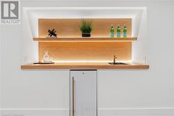 Lower level wet bar area. Oak shelving & counter, sink, bar fridge, ambient lighting - 