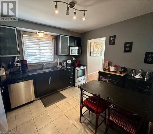 Main floor eat-in Kitchen w/black granite counter tops, SS appliances, and pullout pantry cupboard - 16 Flamingo Drive, Hamilton, ON - Indoor