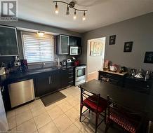 Main floor eat-in Kitchen w/black granite counter tops, SS appliances, and pullout pantry cupboard - 