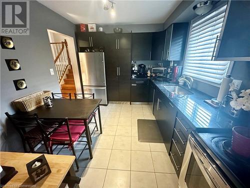 Main floor eat-in Kitchen w/black granite counter tops, SS appliances, and pullout pantry cupboard - 16 Flamingo Drive, Hamilton, ON - Indoor