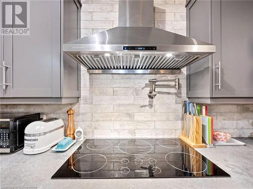 Kitchen in upper unit (2nd flr). Built-in stove top with hood vent and pot-filler! Patterned subway tile backsplash - 213 Caroline Street S, Hamilton, ON 