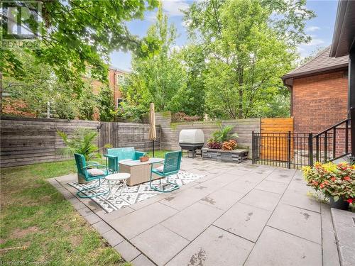 Large (and private) yard surrounded by mature trees, extensive patio with walkway, and fully fenced - 213 Caroline Street S, Hamilton, ON 