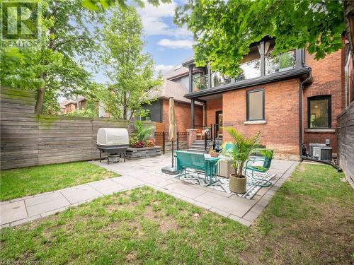 Large (and private) yard surrounded by mature trees, extensive patio with walkway, and fully fenced - 213 Caroline Street S, Hamilton, ON 